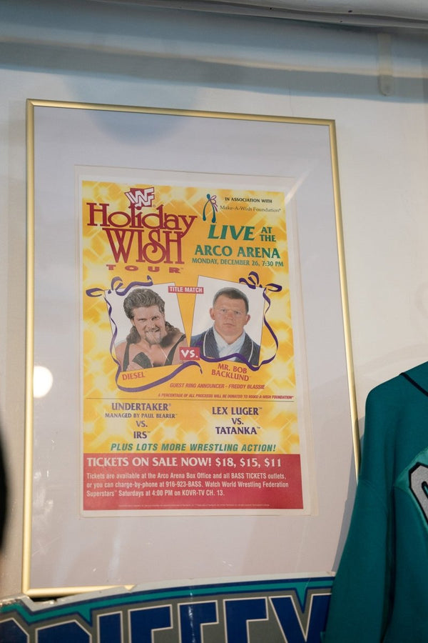 Framed 1994 WWF Holiday Wish Tour promotional poster with Diesel vs Mr Bob Backlund title match on yellow background with ribbon accents