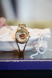 Gold-tone 1995 Armitron bangle watch with Tasmanian Devil Taz character on white dial face and polished gold bangle band