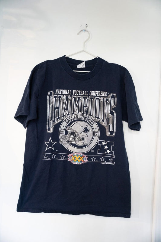 Navy blue 1996 Dallas Cowboys NFC Champions shirt with silver CHAMPIONS lettering, Cowboys helmet badge, and Super Bowl XXX logo