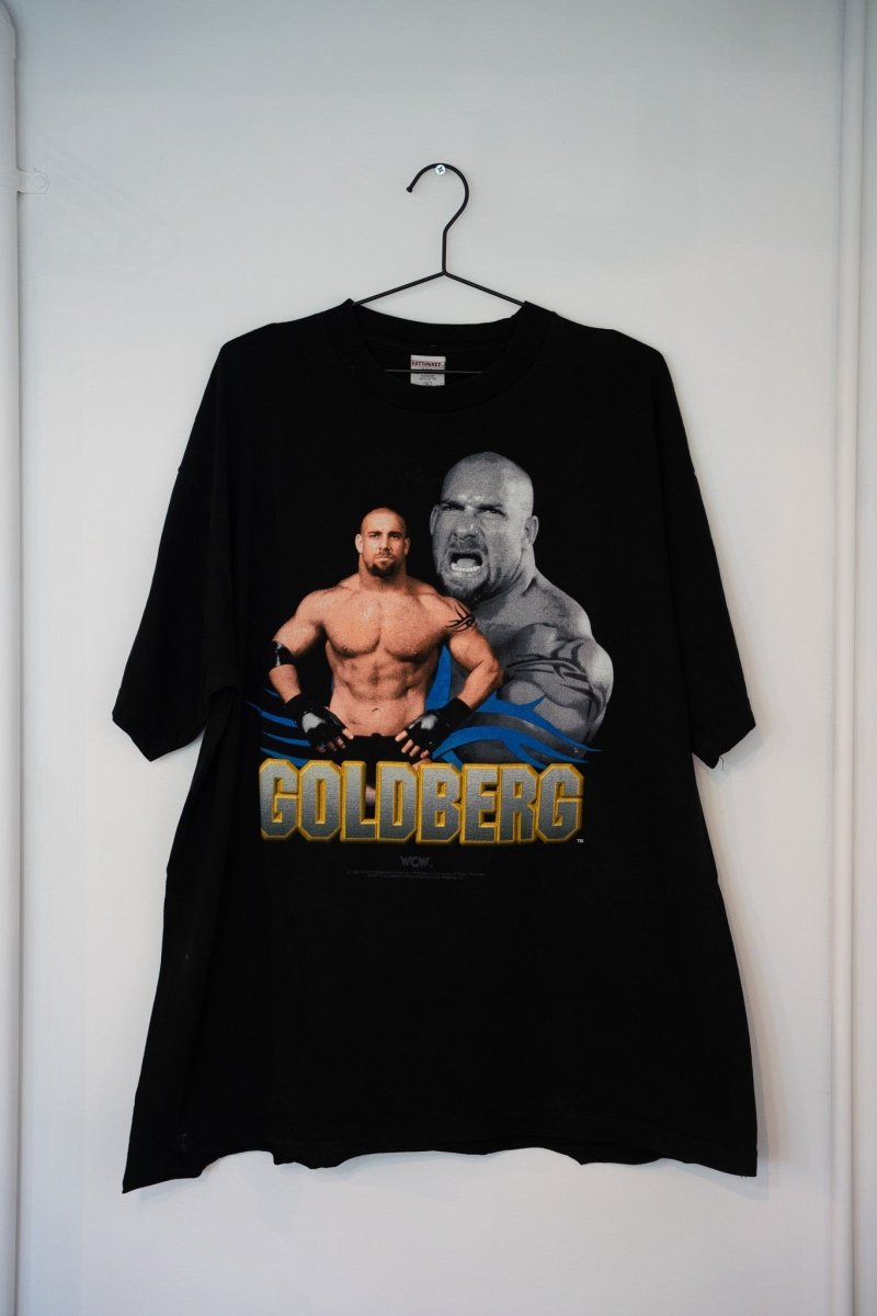 Black 1998 WCW Goldberg tee dual image portrait shirtless muscular screaming close-up blue tribal flames gold GOLDBERG text Cottonnet