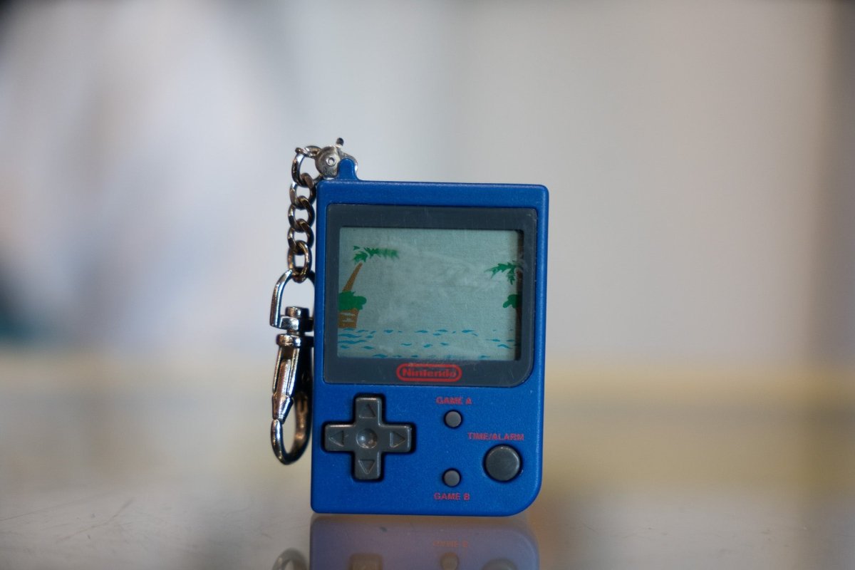 Blue 1998 Nintendo Mini Game Boy keychain with Parachute LCD game screen showing helicopter and rescue boat with red Nintendo logo