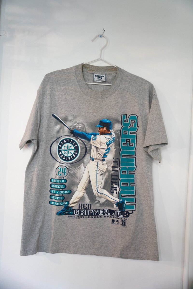 Heather gray 1999 Lee Sport Seattle Mariners Ken Griffey Jr bio t-shirt with full-body swing illustration Mariners logo stat panel and teal SEATTLE MARINERS text size Large