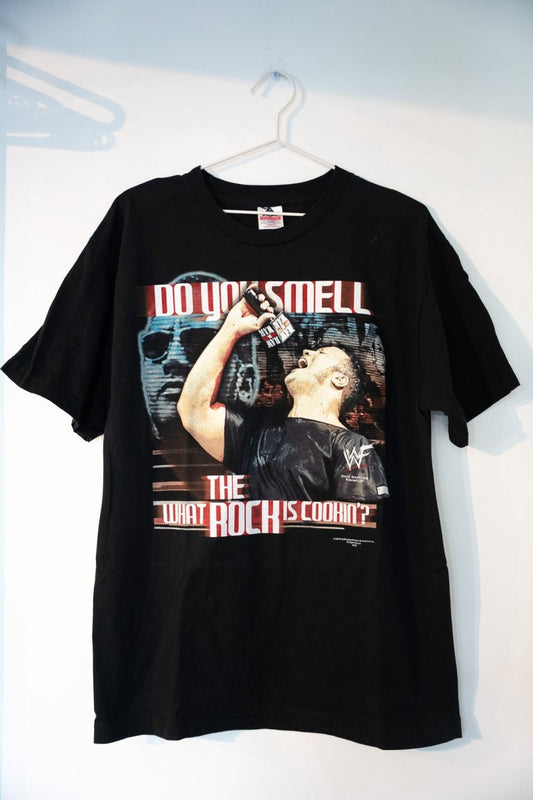 Black 2000 WWF The Rock tee with DO YOU SMELL WHAT THE ROCK IS COOKIN text Rock holding microphone Brahma Bull skull WWF logo size Large