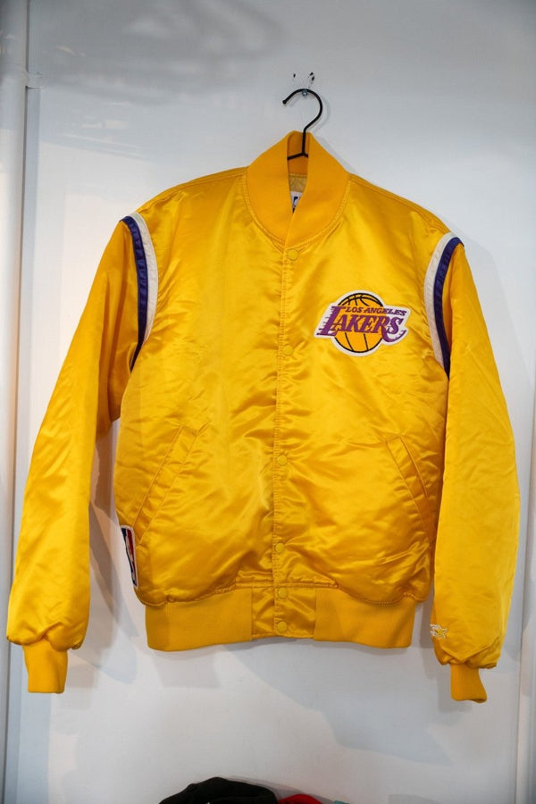 Gold 80s Starter Los Angeles Lakers satin bomber jacket with embroidered Lakers logo, purple and white shoulder stripes, and snap buttons