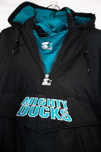 Starter Anaheim Mighty Ducks colorblock puffer anorak jacket in black, purple, and teal from the 1990s, displayed on a hanger