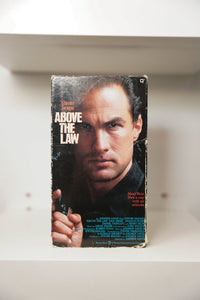 Above the Law VHS cover with Steven Seagal close-up holding gun in leather jacket, Meet Nico tagline, Warner Bros