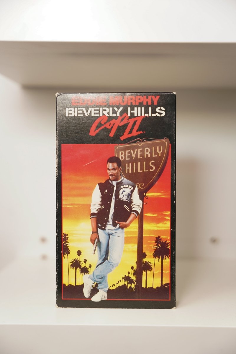 VHS Beverly Hills Cop II Eddie Murphy Detroit Lions letterman jacket gun Beverly Hills sign sunset palm trees EDDIE MURPHY BEVERLY HILLS Cop II text