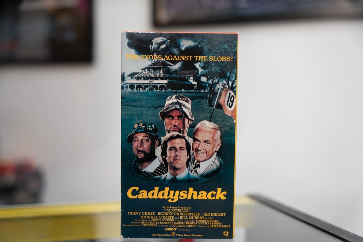 Caddyshack VHS green-toned sleeve with Chevy Chase Bill Murray Rodney Dangerfield Ted Knight golf course gopher yellow Caddyshack script Snobs Against Slobs tagline