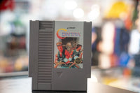 Konami Contra Nintendo NES cartridge from 1988, showing black plastic game case with red and yellow label artwork featuring action game imagery