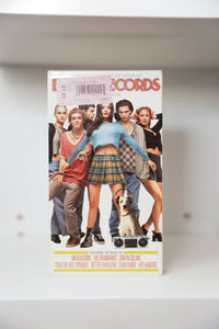 VHS Empire Records white cover ensemble cast Liv Tyler center blue top plaid skirt boombox dog EMPIRE RECORDS orange neon text soundtrack credits