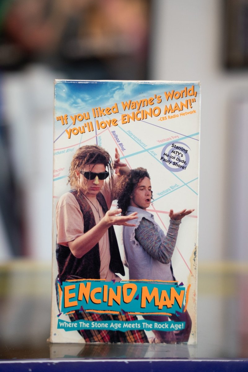 Encino Man VHS tape with Brendan Fraser in sunglasses and Pauly Shore on Encino map background with colorful title lettering