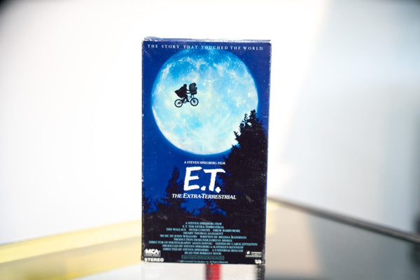 E.T. the Extra-Terrestrial VHS dark blue sleeve with Elliott and ET bicycle silhouette flying across full moon pine trees Steven Spielberg MCA