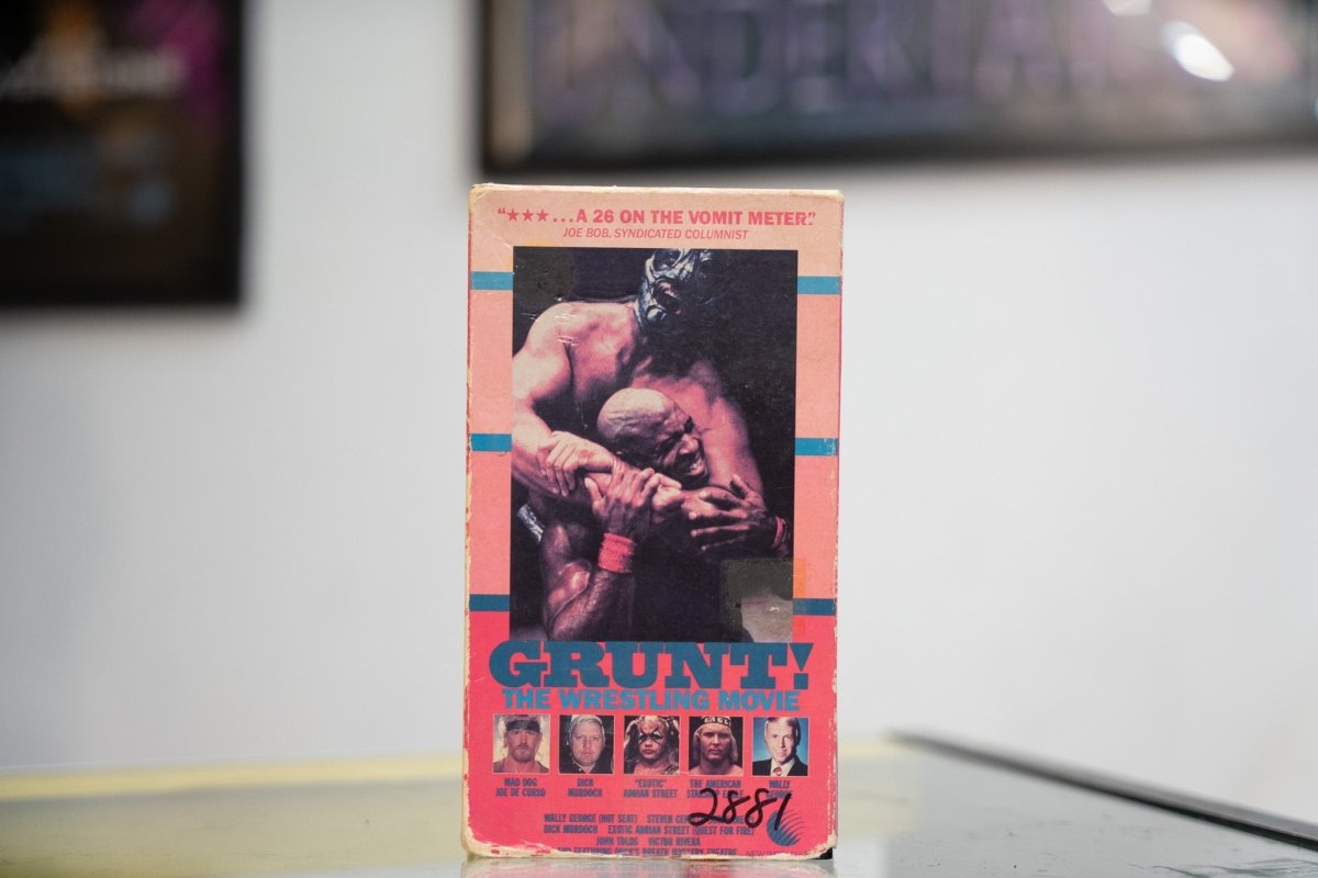 Grunt The Wrestling Movie pink and blue VHS with masked wrestlers in combat Joe Bob Briggs quote red GRUNT title and wrestler headshot photos with heavy wear