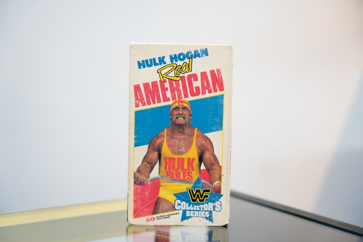 WWF Hulk Hogan Real American VHS tape Collector's Series yellow Hulk Rules tank top red headband double bicep flex blue AMERICAN text