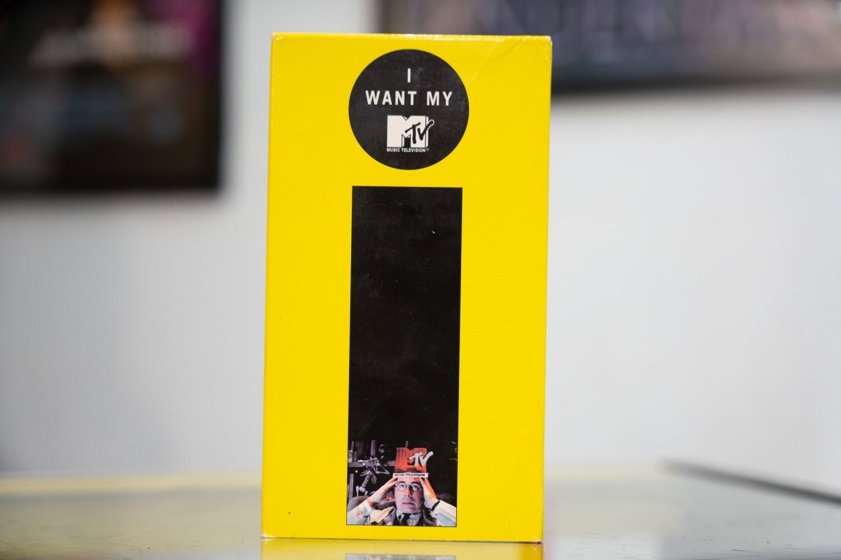 Yellow I Want My MTV VHS sleeve with black stripe MTV Music Television logo in black circle and figure holding MTV logo appears sealed