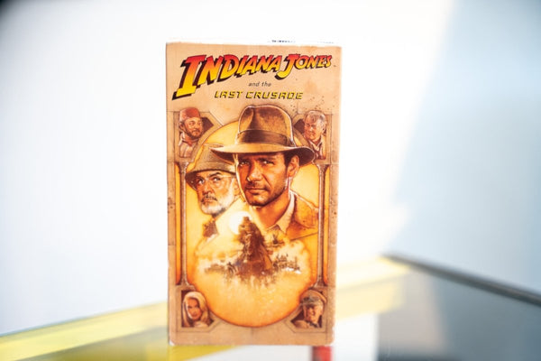 Indiana Jones and the Last Crusade VHS golden painted sleeve Harrison Ford fedora Sean Connery tweed hat horseback scene red yellow Indiana Jones logo