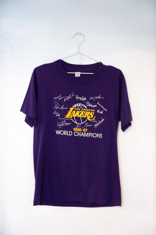 Purple 1987 Los Angeles Lakers World Champions tee gold Lakers logo printed roster signatures 1986-87 WORLD CHAMPIONS white text