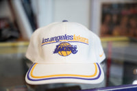 White Los Angeles Lakers Nike fitted cap with purple and gold embroidered lowercase script and Lakers globe logo with pinstripe brim trim