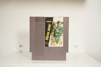 NES Metal Gear gray cartridge soldier Solid Snake green fatigues weapons yellow triangle robots ULTRA logo METAL GEAR metallic text Nintendo