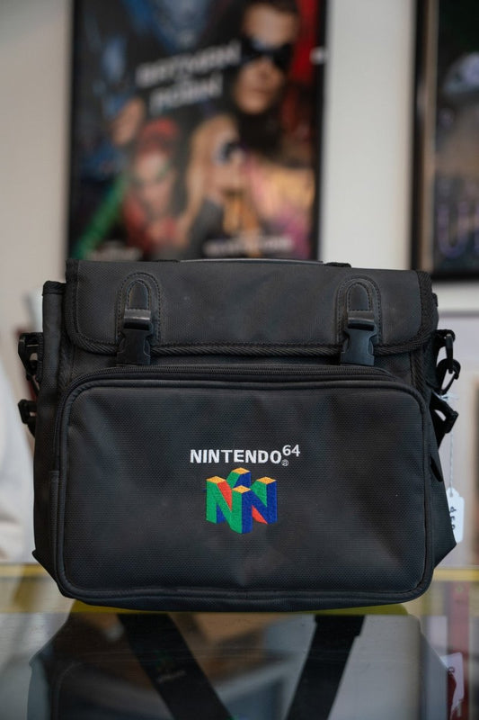 Black Nintendo 64 nylon travel bag with embroidered multicolor N cube logo and NINTENDO 64 text on front flap with buckle closures