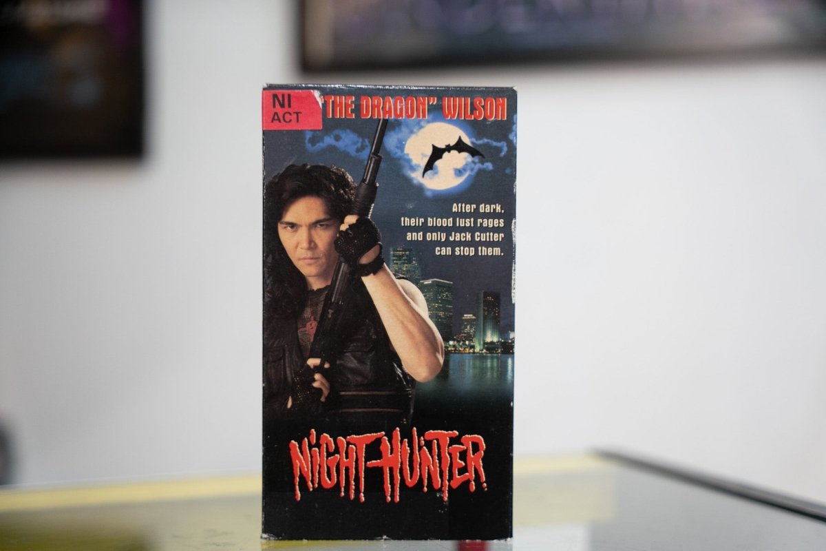 Night Hunter VHS dark sleeve with Don The Dragon Wilson holding shotgun leather jacket city skyline full moon bat silhouette and red dripping title