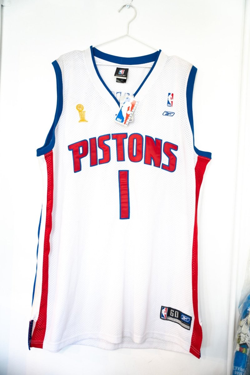 White NWT Chauncey Billups Detroit Pistons number 1 Reebok jersey with red PISTONS lettering gold NBA Finals trophy patch and NBA hangtag size 60