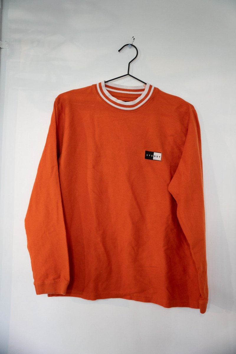 Orange Stussy box logo crewneck sweater with white orange striped rib-knit collar and small Stussy box logo patch on left chest size Small