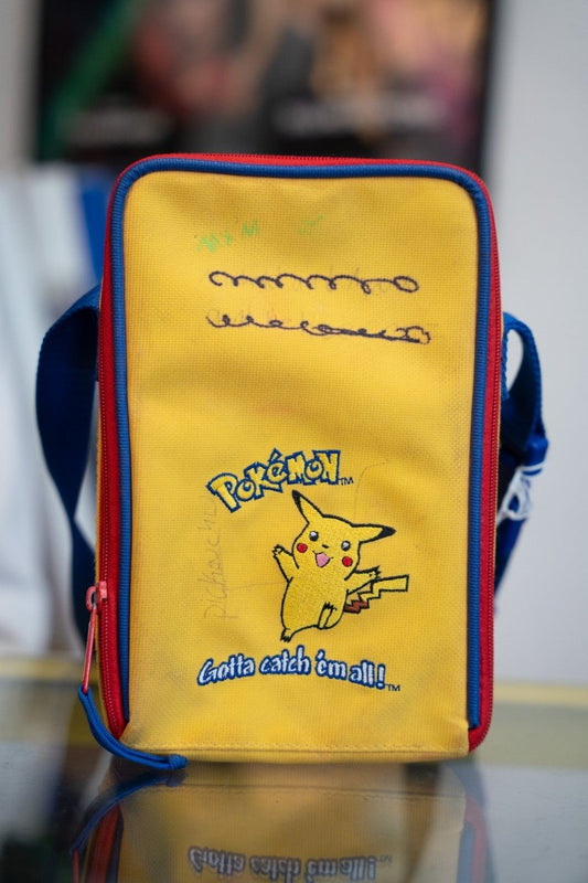 Yellow Pikachu Pokemon Gotta Catch Em All Game Boy Color carrying case with blue sides, red trim, and embroidered Pikachu with marker marks