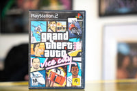 PlayStation 2 Grand Theft Auto Vice City black case with illustrated collage cover art helicopter mansion motorcycle and pink neon Vice City cursive logo
