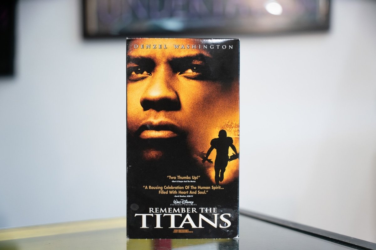 Remember the Titans VHS amber sleeve with Denzel Washington close-up silhouetted football player golden glow Disney white REMEMBER THE TITANS title