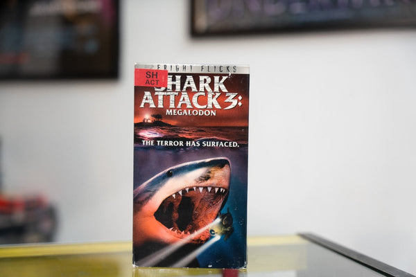 Shark Attack 3 Megalodon VHS red orange sleeve with massive shark jaws open scuba diver lighthouse Fright Flicks banner and The Terror Has Surfaced tagline