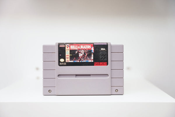 SNES Bulls vs Blazers grey cartridge with NBA game action photo, team logos, Electronic Arts logo, Made in Japan