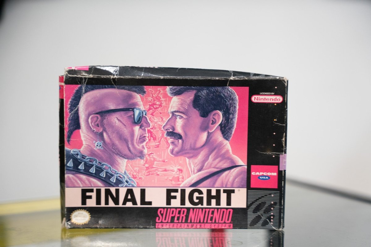 SNES Final Fight box with two tough guys face-off artwork, punk with sunglasses versus mustachioed man, Capcom USA logo, significant box wear