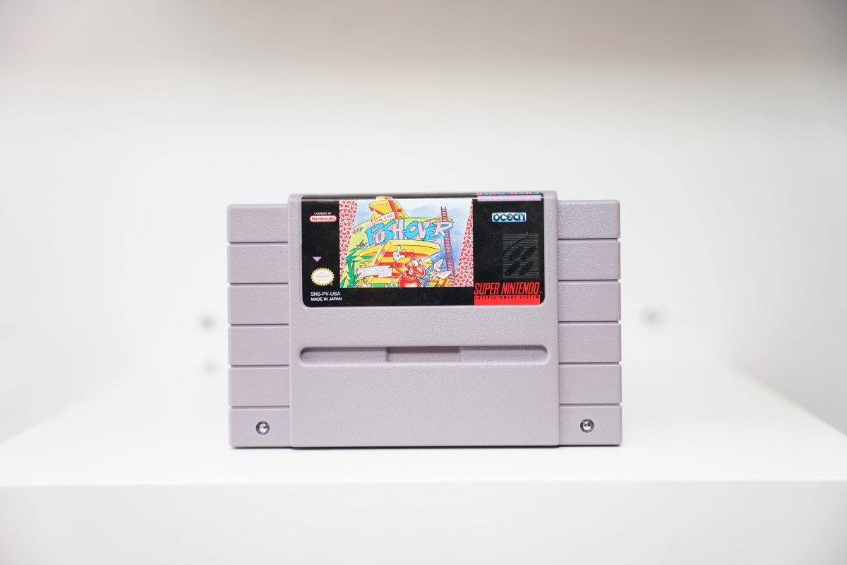 SNES Push-Over grey cartridge with cartoon red ant character among colorful domino blocks and ladders, Ocean logo