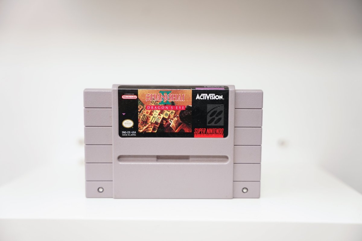 SNES Shanghai II Dragon's Eye grey cartridge with Mahjong tiles in pyramid formation, gold Shanghai II text, Activision logo