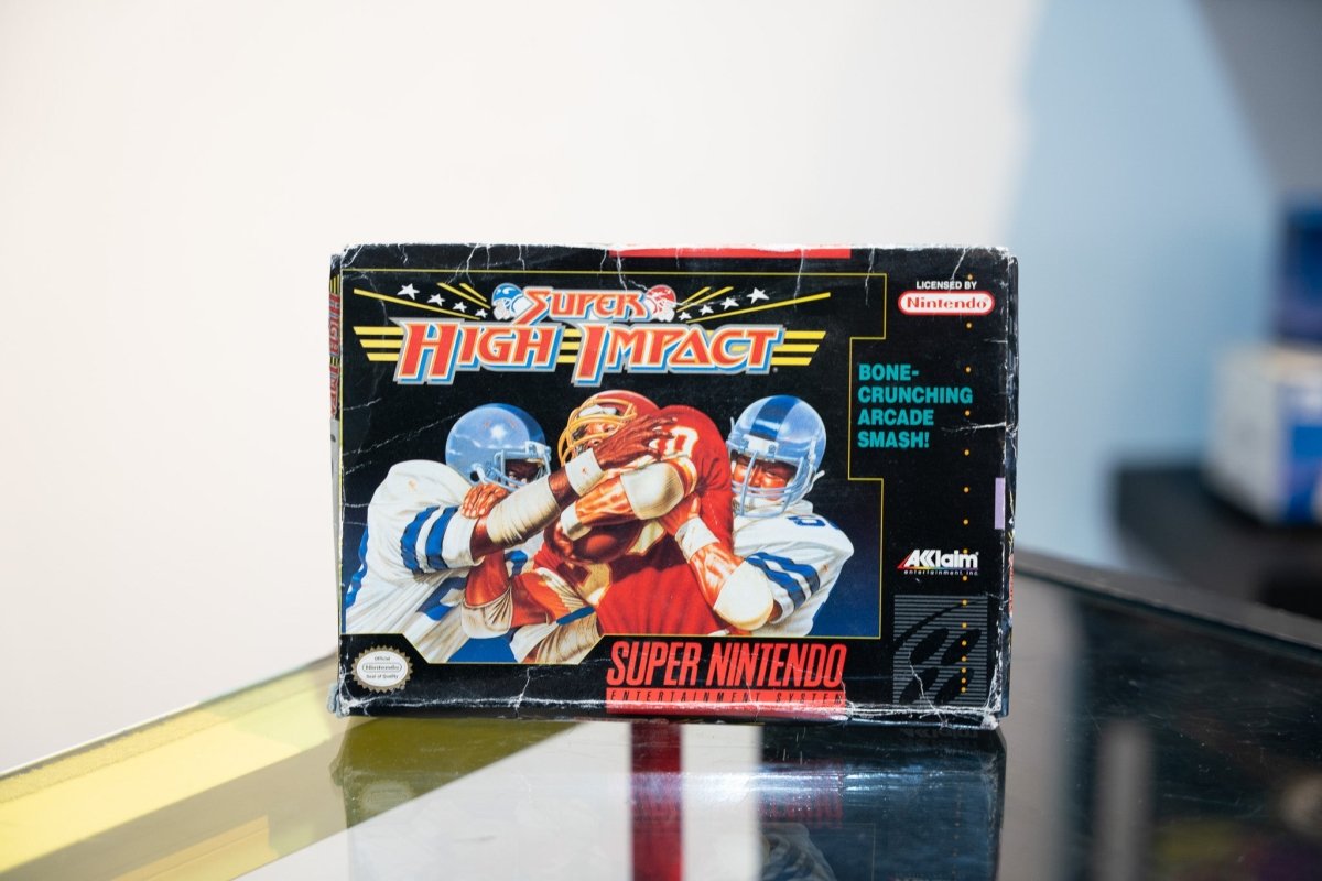 SNES Super High Impact box with intense football tackle illustration, Bone-Crunching Arcade Smash tagline, Acclaim logo, box shows wear