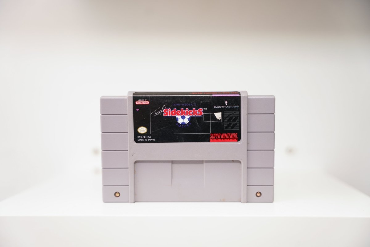 SNES Tony Meola's Sidekicks Soccer grey cartridge with Sidekicks logo, soccer ball, Tony Meola signature, Electro Brain logo