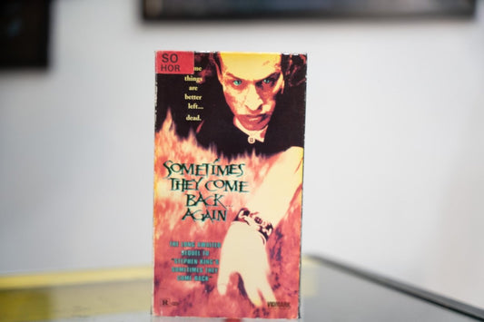 Sometimes They Come Back Again VHS fiery sleeve with dark figure glowing green eyes emerging from flames green metallic title and Vidmark Entertainment