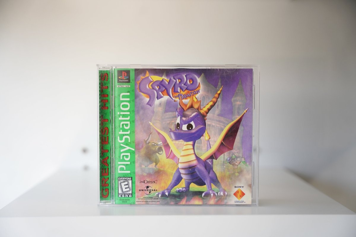 PlayStation Spyro the Dragon Greatest Hits green label purple dragon orange horns castle backdrop SPYRO the Dragon purple gold text Insomniac Sony