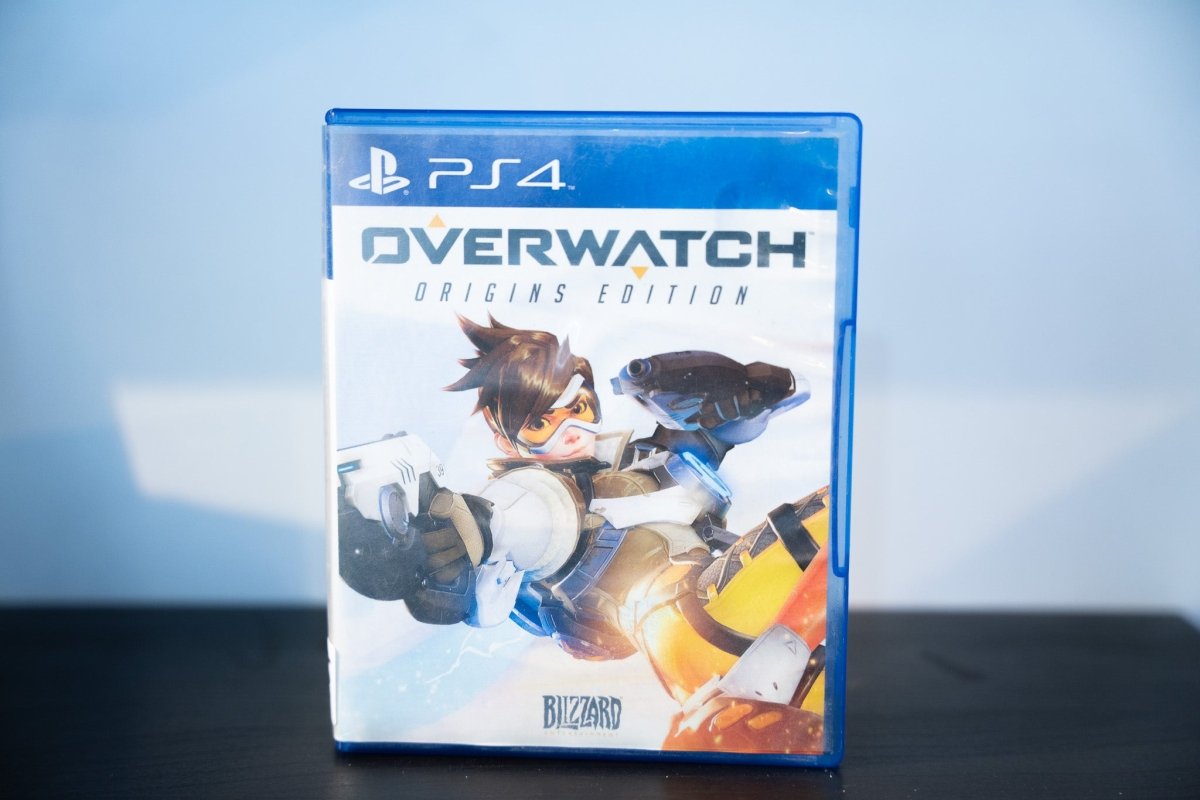 PS4 Overwatch Origins Edition blue case Tracer dynamic pose dual pistols goggles flight suit OVERWATCH white text Blizzard Teen rating