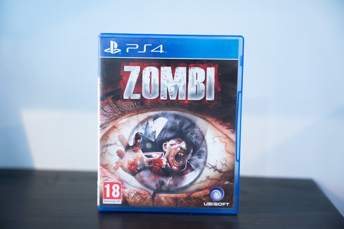 PS4 Zombi blue case extreme close-up bloodshot eye zombie reflection ZOMBI distressed blood-splattered text Ubisoft PEGI 18