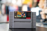 Nintendo Super Play Action Football cartridge for Super NES, showing the game box with football player artwork and title text on a dark background