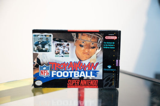 Super Nintendo Troy Aikman NFL Football box Troy Aikman Cowboys helmet close-up action photos Troy Aikman red script NFL Football text Tradewest