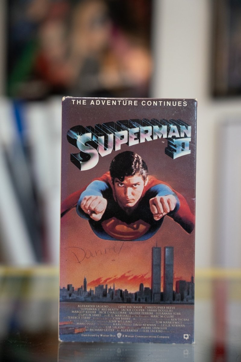 Superman II VHS tape with Christopher Reeve flying toward camera over city skyline against orange sunset with chrome SUPERMAN II title