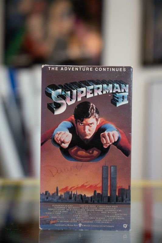 Superman II VHS tape with Christopher Reeve flying toward camera over city skyline against orange sunset with chrome SUPERMAN II title