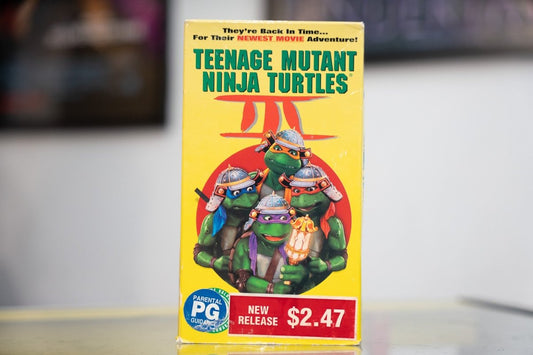 Yellow Teenage Mutant Ninja Turtles III VHS case with four Turtles in samurai armor against red rising sun circle and green title lettering