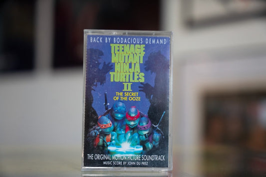 TMNT II The Secret of the Ooze soundtrack cassette tape with four Turtles and glowing ooze artwork in clear case