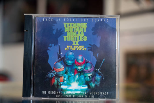 Teenage Mutant Ninja Turtles II The Secret of the Ooze soundtrack CD with four Turtles around glowing ooze canister on blue cover