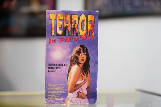 Purple Terror in Paradise VHS sleeve with woman in white dress on beach explosions behind her red yellow title and Concorde Pictures release