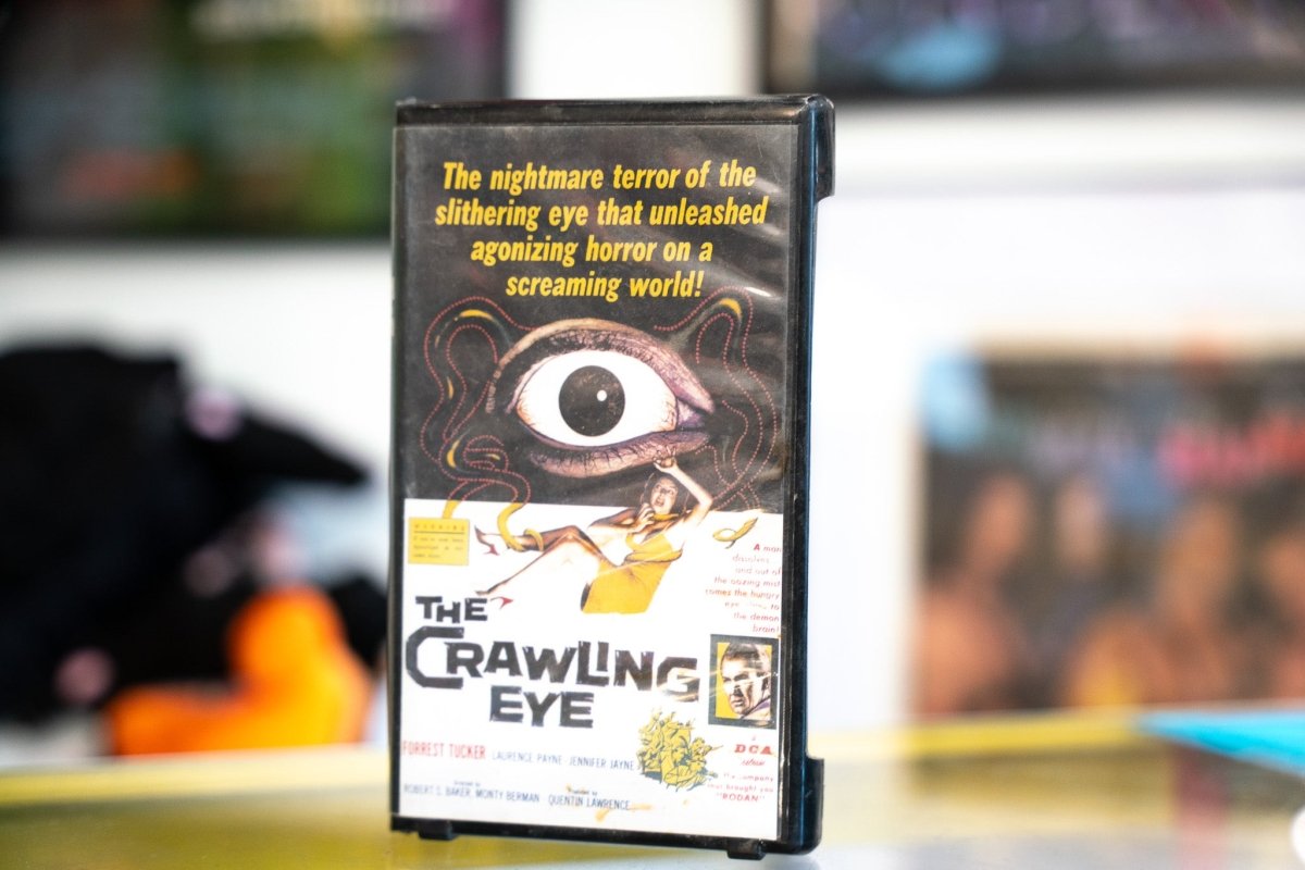 The Crawling Eye VHS with original poster art of giant tentacled eyeball over terrified woman yellow tagline text and white horror-style title lettering